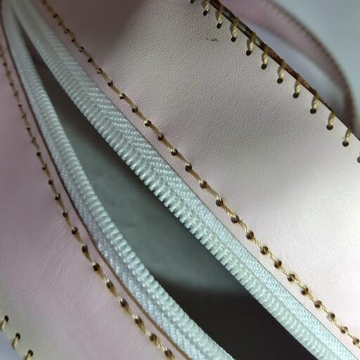 کیف چرمی گرد یا دایره ای صورتی با بند بلند که سه جا دارد قسمت اصلی پشت و جلوی کیف