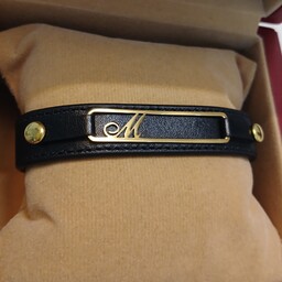 دستبند حرف M استیل طلایی با چرم مشکی مناسب برای خانمها و اقایان