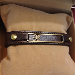دستبند چرم B  استیل طلایی با چرم قهوه ای سوخته اصل