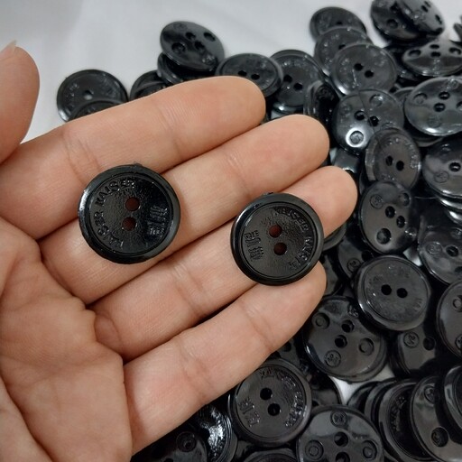 دکمه مانتویی سیاه پک پنجاه تایی دکمه مشکی دو سانتی دکمه سیاه دوسوراخ عمده هم موجود در خرازی نفیس