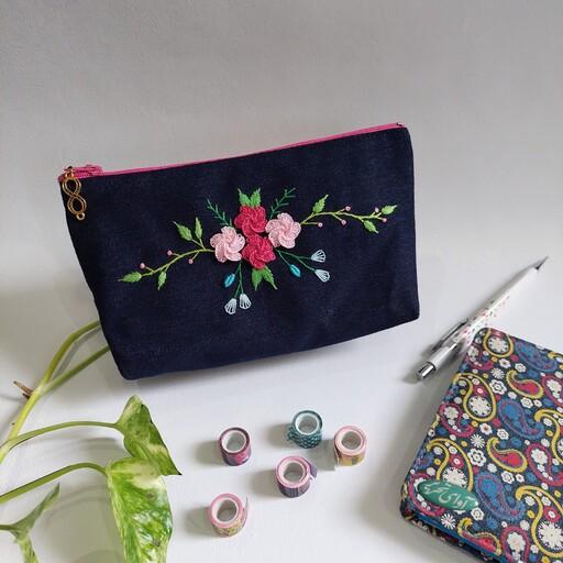 جامدادی کیف آرایش گلدوزی شده با دست دست دوز طرح گلهای صورتی و غنچه های آبی و سفید