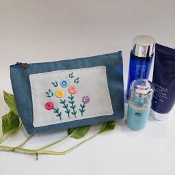 کیف لوازم آرایش گلدوزی شده با دست پارچه مبلی دست دوز رنگ آبی تیره طرح گل شاخه های گل رنگی