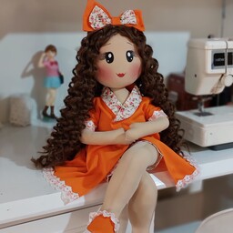 عروسک رولی  با لباس نارنجی و مو های فرفری جذاب
