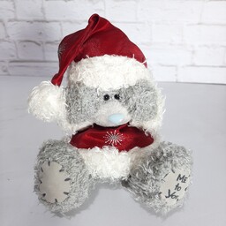 عروسک خرس محبوب و زیبای برند می تو یو با لباس کریسمسی دست هاش را گذاشته کنار سرش روی کلاهش
