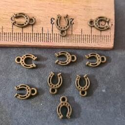 خرجکار  نعل  کوچک آویز  برنزی ، حلقه دار ( پَک 18عددی )مناسب  ساخت دستبند ،مناسب زیورآلات وبدلیجات وکارهای هنری...