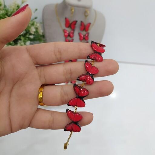 ست پروانه قرمز شامل گردنبند تک ،گوشواره سه پروانه،دستبند پنج پروانه اتصالات رنگ ثابت و گیرمو و انگشتر کیفیت معمولی