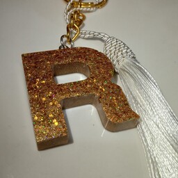 دسته کلید رزینی طلایی طرح حرف R به همراه آویز 
