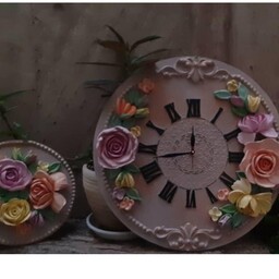 ساعت زیبایی با گل های برجسته همراه با دوتا تابلوی کوچک گل در کنارش 