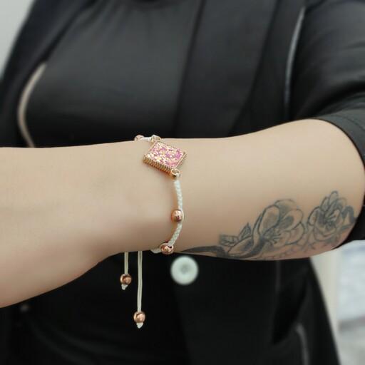دستبند زنانه و دخترانه دستبافت با مهره های حدید طلایی توپی و نشان منشوری لوزی صورتی