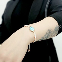 دستبند زنانه و دخترانه دستبافت با مهره های حدید طلایی توپی و نشان منشوری فیروزه ای