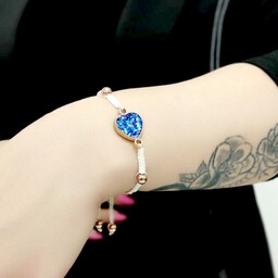 دستبند زنانه و دخترانه دستبافت با مهره های حدید طلایی توپی و نشان منشوری قلبی آبی تیره