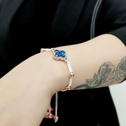 دستبند زنانه و دخترانه دستبافت با مهره های حدید طلایی توپی و نشان منشوری آبی تیره
