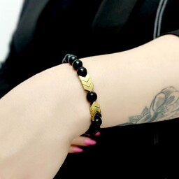 دستبند دخترانه و زنانه سنگ اونیکس سیاه براق با نشان سنگ حدید جهت دار طلایی