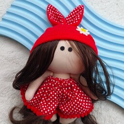 عروسک روسی قرمز با گل بابونه روی کلاه، قد 15 سانت،جنس بدن پارچه کرپ باربی،لباس کتان نخ،مو الیاف مصنوعی