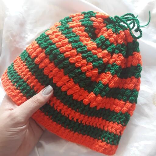 کلاه بافتنی مدل اشکی در ترکیب رنگ های سبز و نارنجی و سایز های مختلف مخصوص دختران و زنان در فصل زمستان