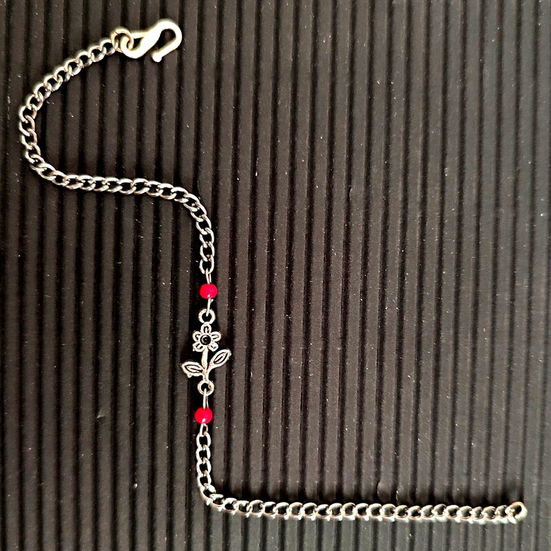 دستبند زنجیری نقره ای قفل دار با  پلاک گل سیاه قلم و 2 مهره بسیار  ظریف قرمز  براق و  قفل اس