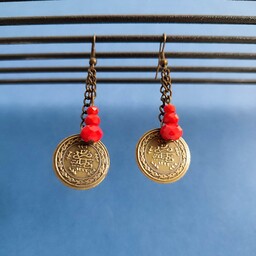 گوشواره با ترکیب  سکه برنزی و کریستال قرمز .  بصورت آویزی و  جفت می باشد