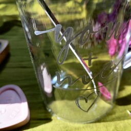 ماگ شیشه ای طرحدار با درب مشکی و قاشق فلزی نقره ای