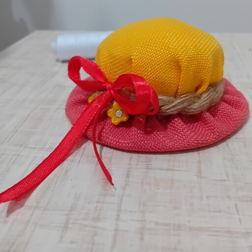جاسوزنی طرح کلاه تهیه شده از پارچه کنفی مناسب کارهای خیاطی کارشده با نخ کنفی وروبان قرمز نیم سانت