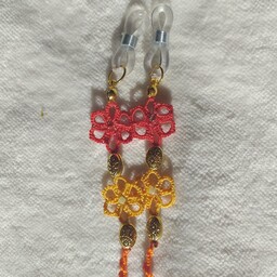 بند عینک بافت گیپوربافی در طیف نارنجی و قرنز و زرد با گل های بافت کوچک تهییه شده از نخ ابریشمین 