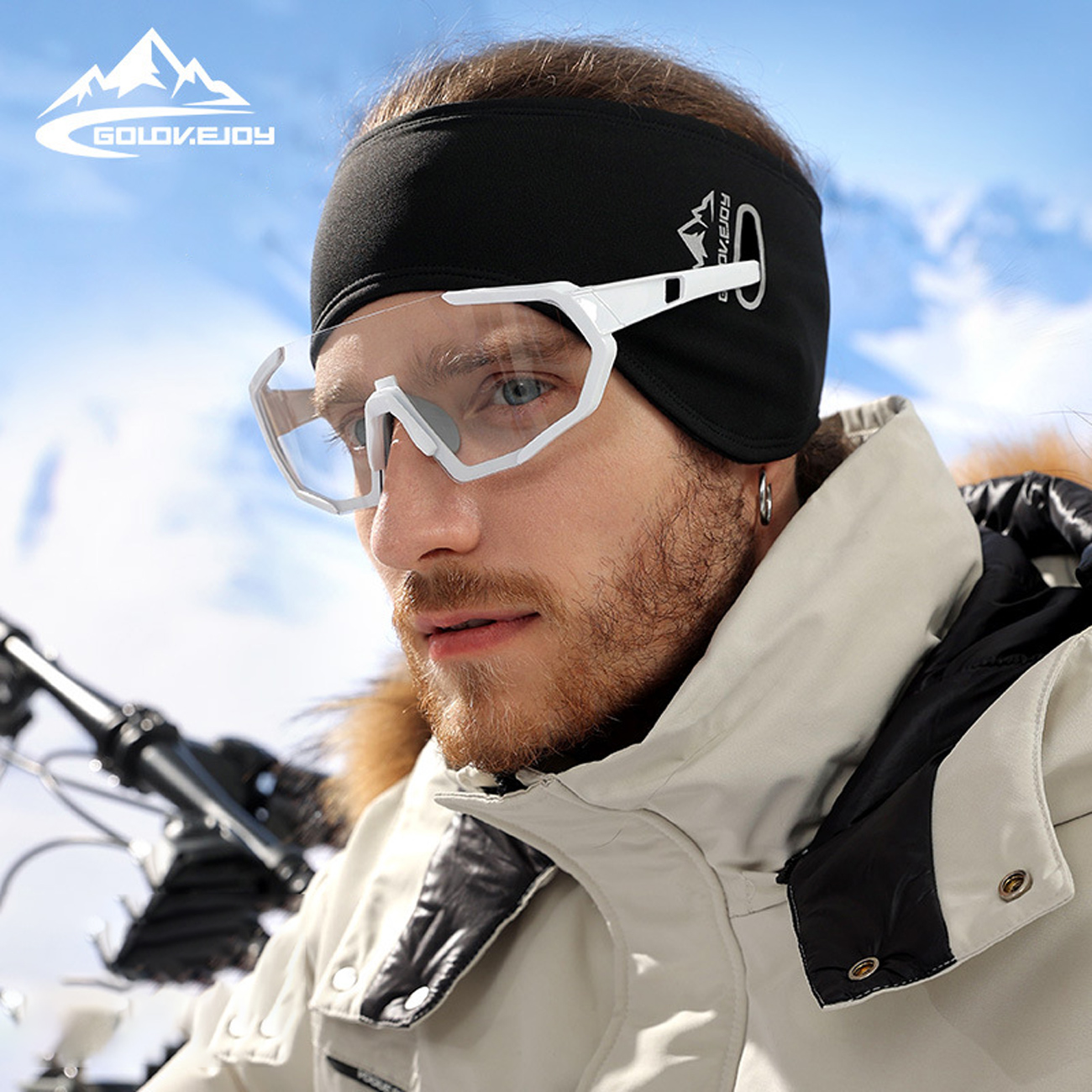 مردی با هدبند گرم و عینک ورزشی سفید در برف