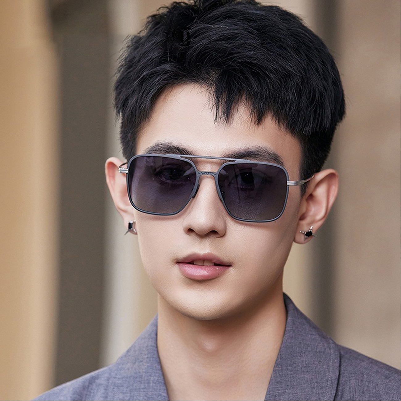 مردی جوان با عینک آفتابی مردانه کارن بازار مدل B9703، لنزهای پلاریزه UV400، فریم تیتانیومی سبک و طراحی اسپرت.