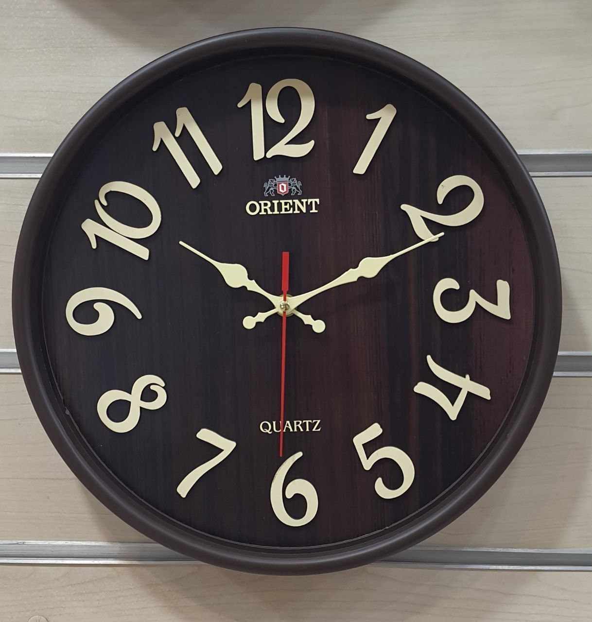 ساعت دیواری اورینت قهوه‌ای طرح چوب 32 سانتیمتری آرامگرد