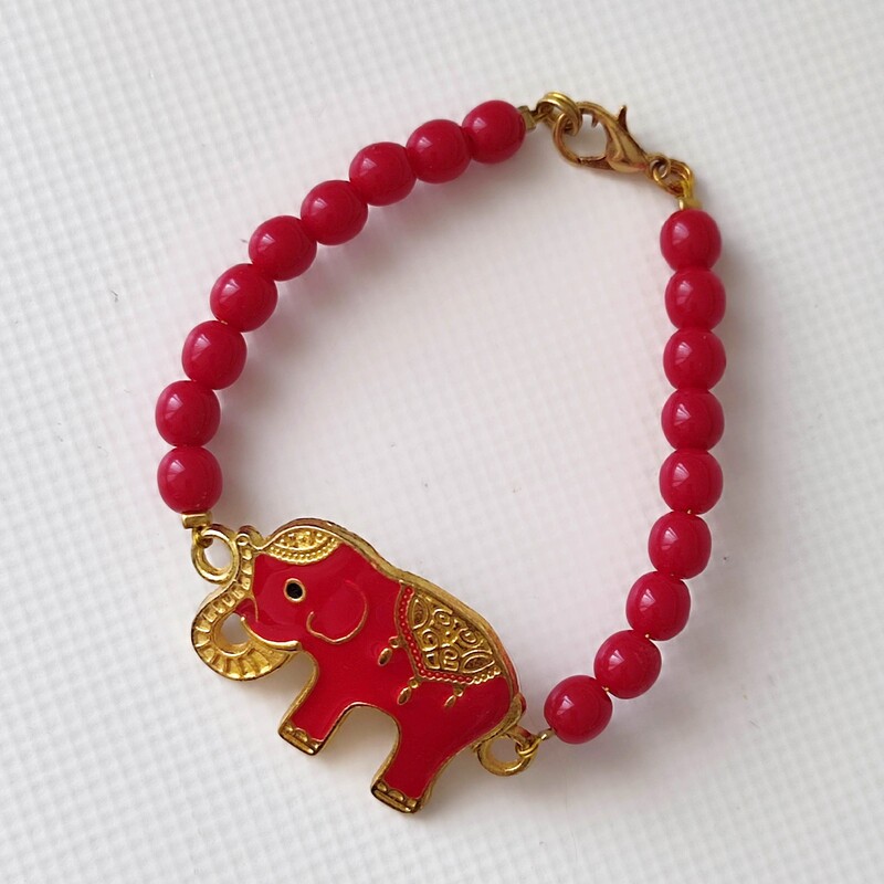 دستبند قرمز با پلاک فیل هندی قرمز و حاشیه طلایی  با مهره قرمز
