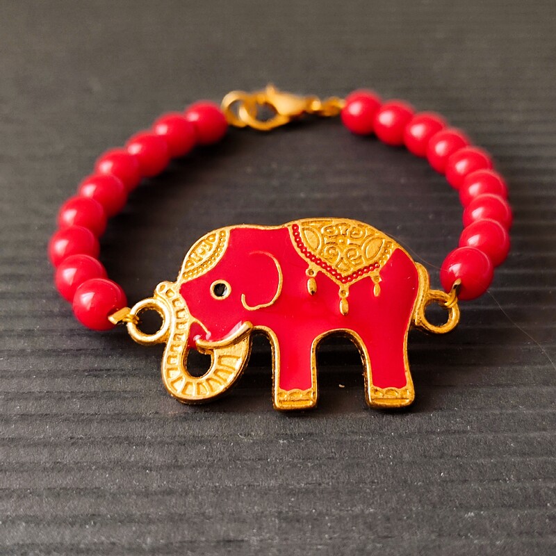 دستبند قرمز با پلاک فیل هندی قرمز و حاشیه طلایی  با مهره قرمز