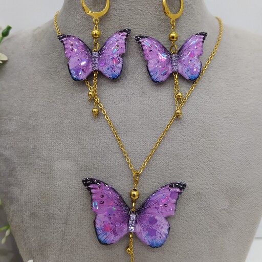 ست چهارتیکه ی پروانه بنفش شاین دار شامل گردنبند،گوشواره،تمیمه با اتصالات رنگ ثابت و گیرمو هدیه