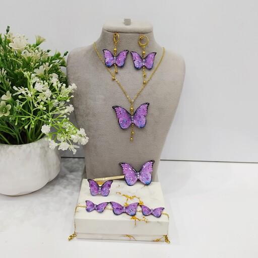 ست پنج تکه پروانه بنفش شاین دار شامل گردنبند،گوشواره،دستبند رنگ ثابت و گیرمو انگشتر کیفیت معمولی