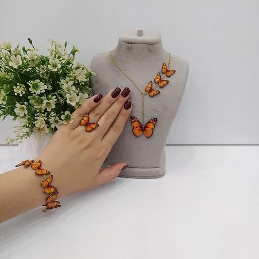 ست سه تیکه پروانه نارنجی شامل گردنبند و دستبند رنگ ثابت و انگشتر کیفیت معمولی 