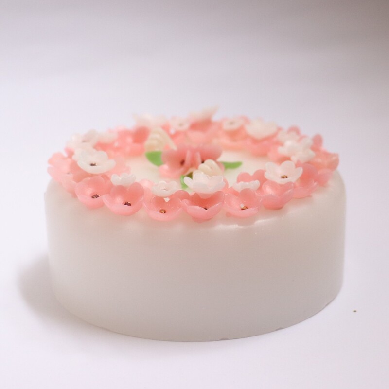 شمع استوانه ای کیکی گل گلیدصورتی و سفید دو فیتیله پارافین گل دست ساز جواهر