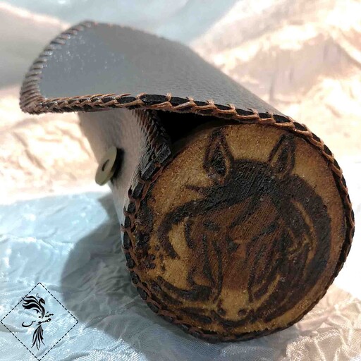 کیف استوانه ای چوب و چرم دست دوز ققنوس به همراه قطعه سوخته نگاری بر روی کُنده درخت گردو طرح اسب