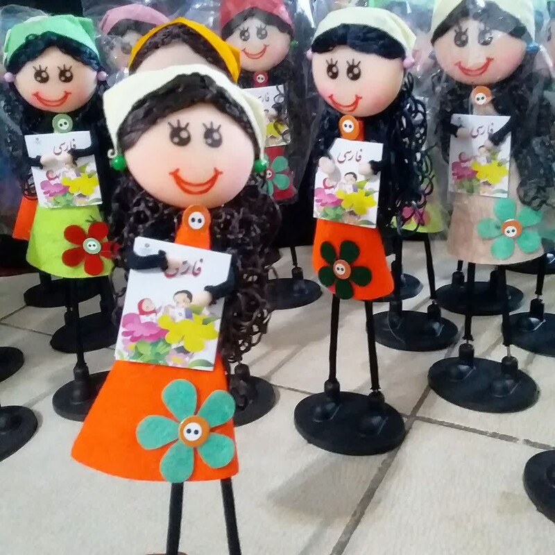 عروسک فانتزی دانش آموز کتاب فارسی به دست 