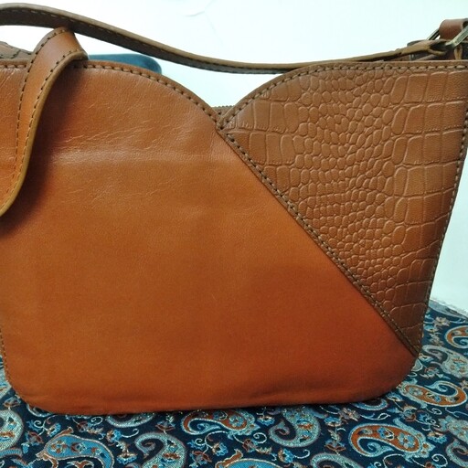 کیف دوشی زنانه .تهیه شده از چرم طبیعی بز بوده و به روش دست دوز ساخته و پرداخته شده است.