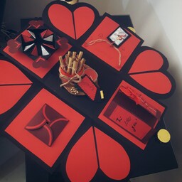 جعبه سوپرایز هدیه مشکی قرمز با گیفت چوبی وسط  متن عاشقانه لول شده و شمع 
