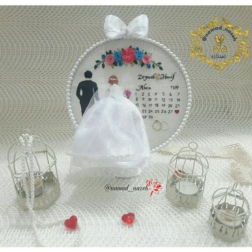 قاب دیوارکوب گلدوزی عروس و داماد با گلهای گلدوزی شده و تقویم .در مدلها و رنگهای  دلخواه شما