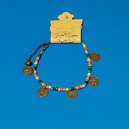 پابند.کار شده با مهره های رنگارنگ و دارای آویزهای طرح سکه از جنس برنز،قفل و حلقه چه هم برنز میباشد.
