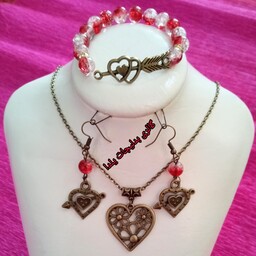 ست ولنتاین طرح برنزی قلبی با کشکول برنزی قلبی وتزئین شده با مروارید گلس قرمز و سفید .دستبند به صورت کشی است.