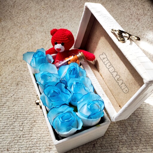 باکس گل صندوقی مستطیل چرمی سفید با گل های مصنوعی آبی و خرس و اسمارتیز . کادو هدیه عیدی سال نو سوپرایز