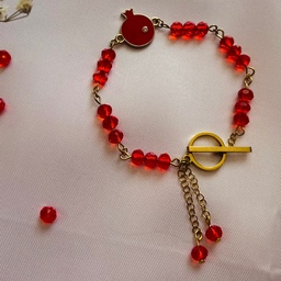 دستبند زنانه(دخترانه)کریستال قرمز با پلاک انار  و اتصالات و زنجیر استیل-قفل تی