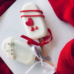 پاپسیکلز با شکلات سفید و مغزی کیک شکلاتی با تزئینات برای ولنتاین و میز کندی بار