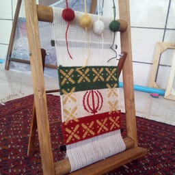 گلیم ورنی بافته شده روی دار چوبی با طرح پرچم مقدس ایران و تلفیق نماد درفش کاویانی