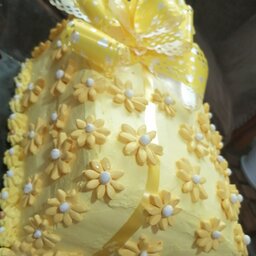 کیک تولد خانگی با طرح کادو رنگ زرد وگلهای بابونه فوندانتی