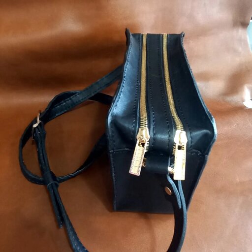 کیف دوشی کوچک و جادار دارای دو قسمت مجزا یک پاکت زیپ دار داخل کیف و بند قابل تنظیم تهیه شده از چرم طبیعی کاملا دست دوز