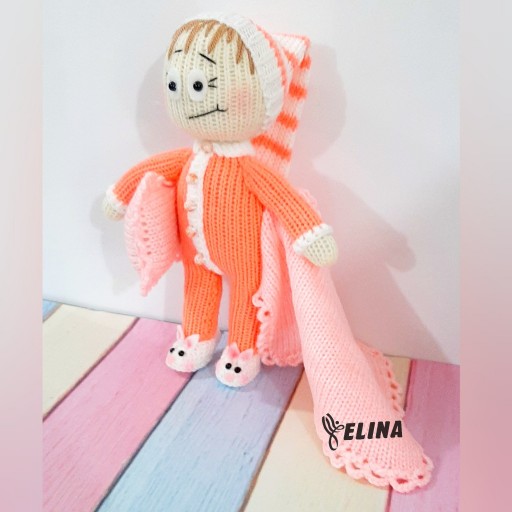عروسک بافتنی نینی بلا شیطون نارنجی رنگ قد بیست وپنج سانتی کلاه دار کفش خرگوشی الینایی با شیشه شیر