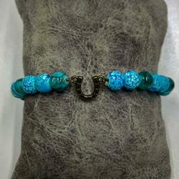 دستبند مدل کشی با مهره های رنگ ثابت ابرنگی به رنگ های آبی و سبز آبی و خرج کار برنزی طرح نعل دوعدد 