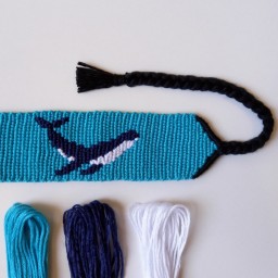 دستبند دوستی دستبافت طرح نهنگ (با پس زمینه فیروزه ای) محصول دستساز تیم گوزن آبی