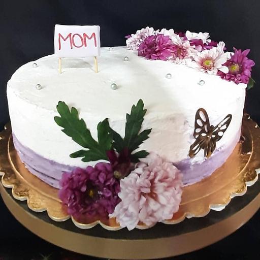 کیک اسفنجی وانیلی با فیلینگ موز و گردو و کاور خامه و تزیین گل طبیعی مناسب روز مادر  